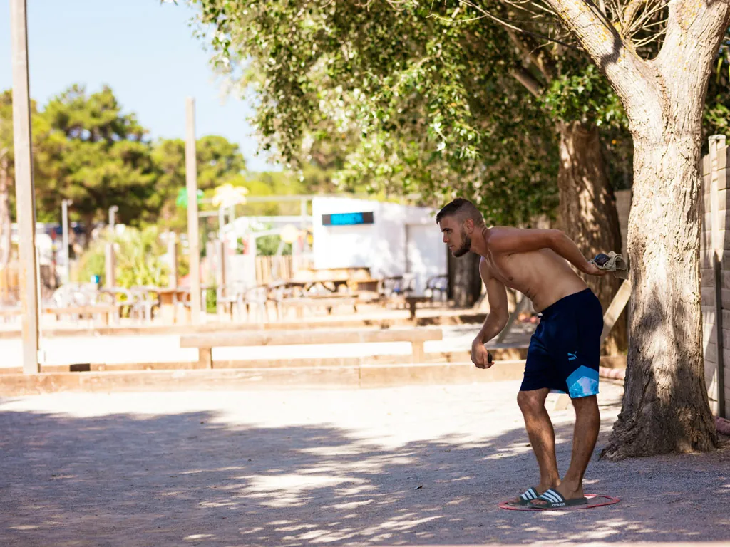 jeune homme qui joue à la pétanque au camping Chadotel Le Trivoly à Torreilles Plages - Pyrénées Orientales