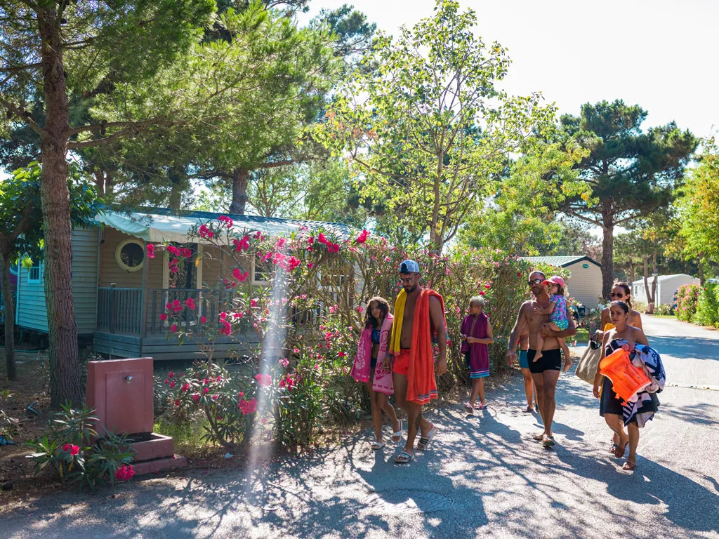 famille dans une allée de camping qui va à la piscine au camping Chadotel Le Trivoly à Torreilles Plages - Pyrénées Orientales