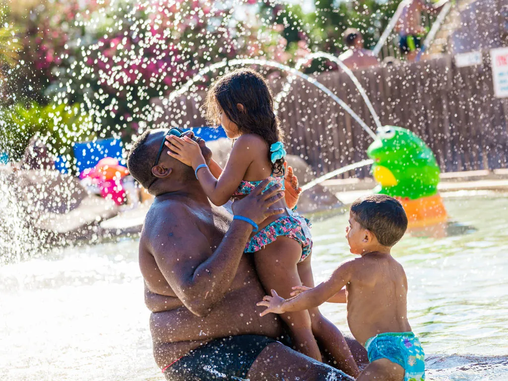 papa qui joue dans le lagon avec ses enfants au camping hadotel Le Trivoly à Torreilles Plages - Pyrénées Orientales