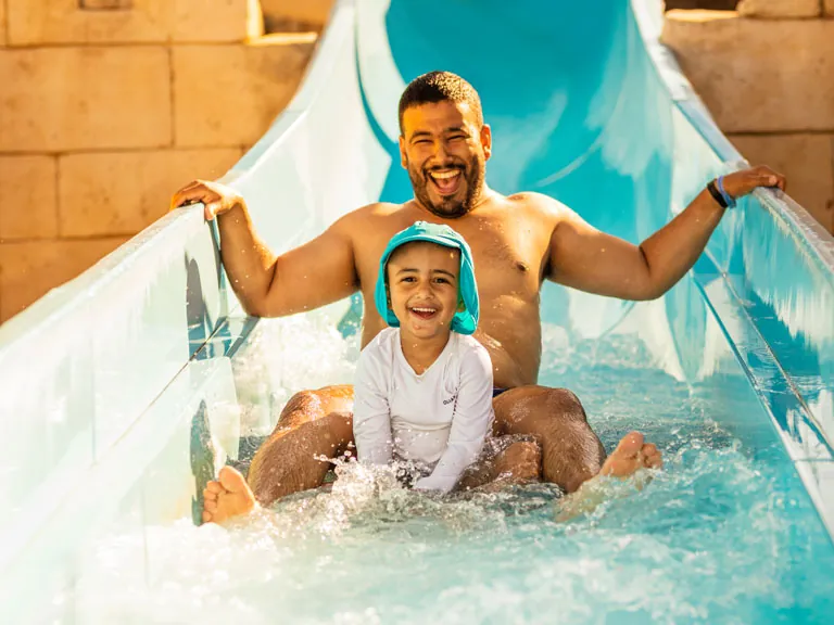 père et son fils dans le toboggan aquatique du camping hadotel Le Trivoly à Torreilles Plages - Pyrénées Orientales