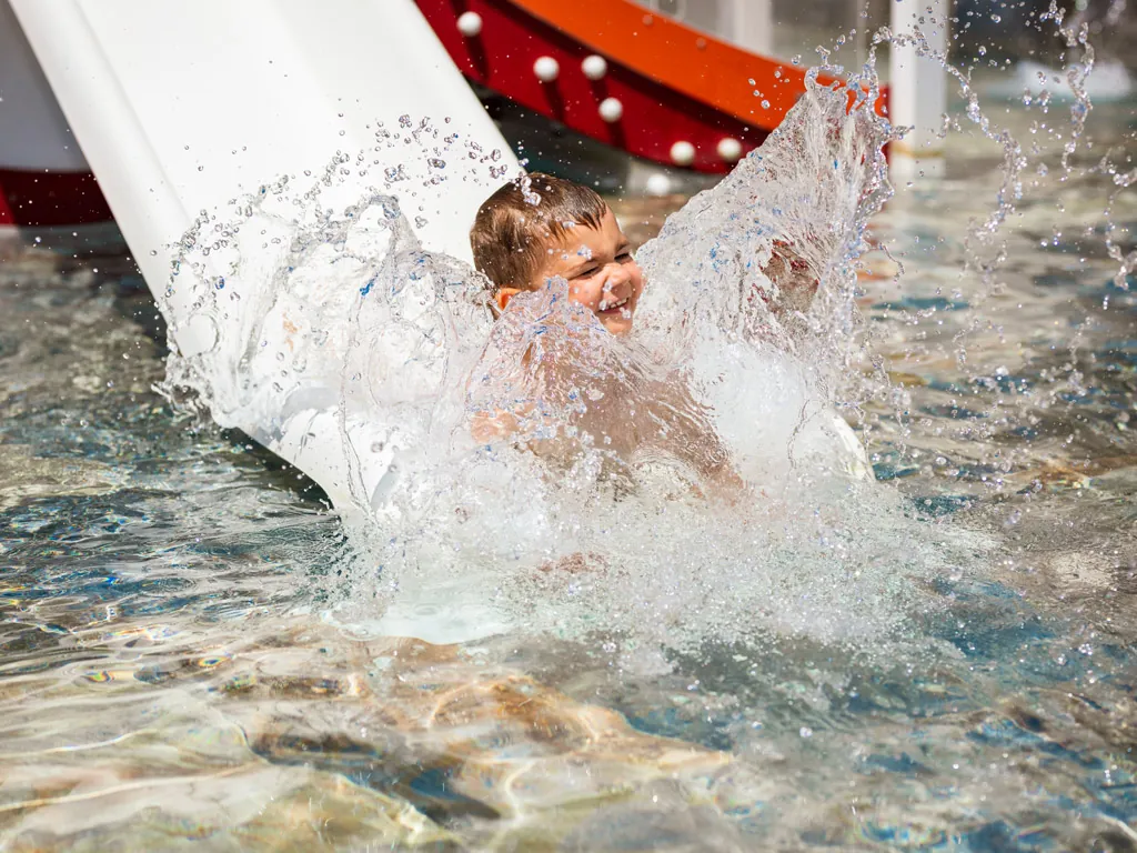 enfant qui glisse dans le toboggan de la pataugeoire du Camping Chadotel Le Roussillon à St Cyprien