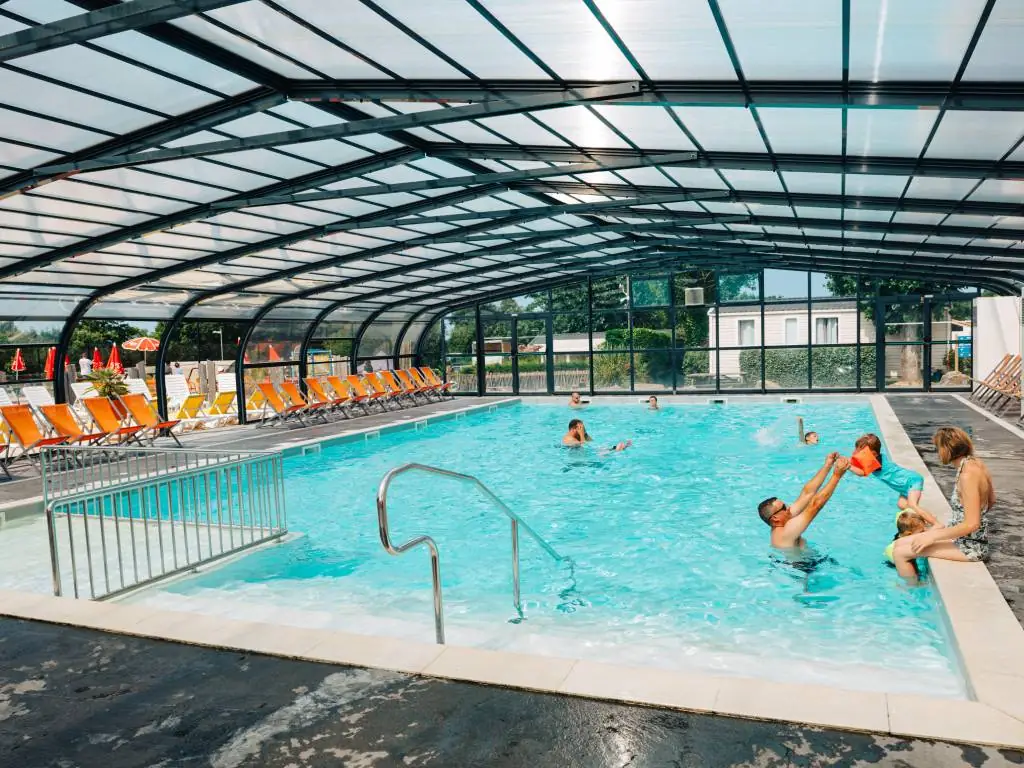 famille qui joue dans la piscine couverte camping Chadotel les Ecureuils à la Bernerie en Retz