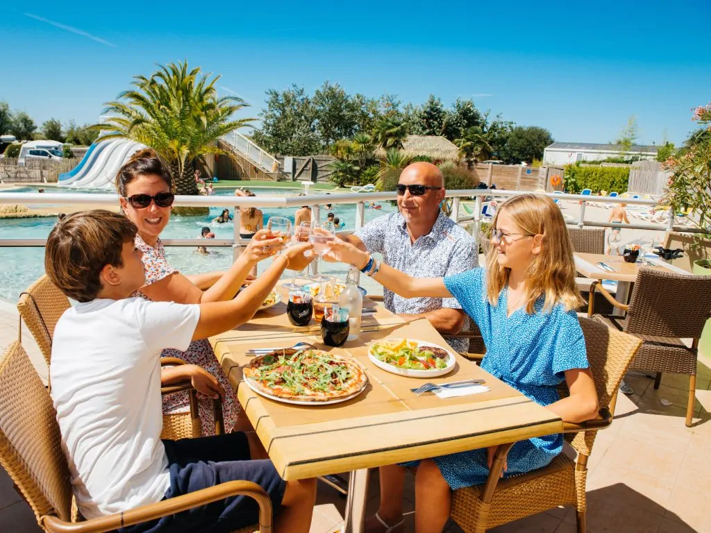 famille qui mange une pizza sur la terrasse du restaurant au camping les iles à pénestin